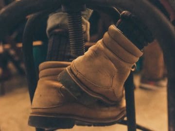 vegan timberlands person wearing boots while sitting on a chair